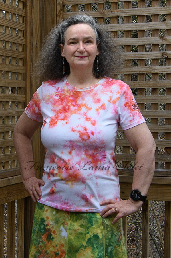Women's handmade and hand dyed short sleeve t-shirt in different shades of pink, peach, white and a bit of yellow with a black lotus flower print on the sleeves - Coralie